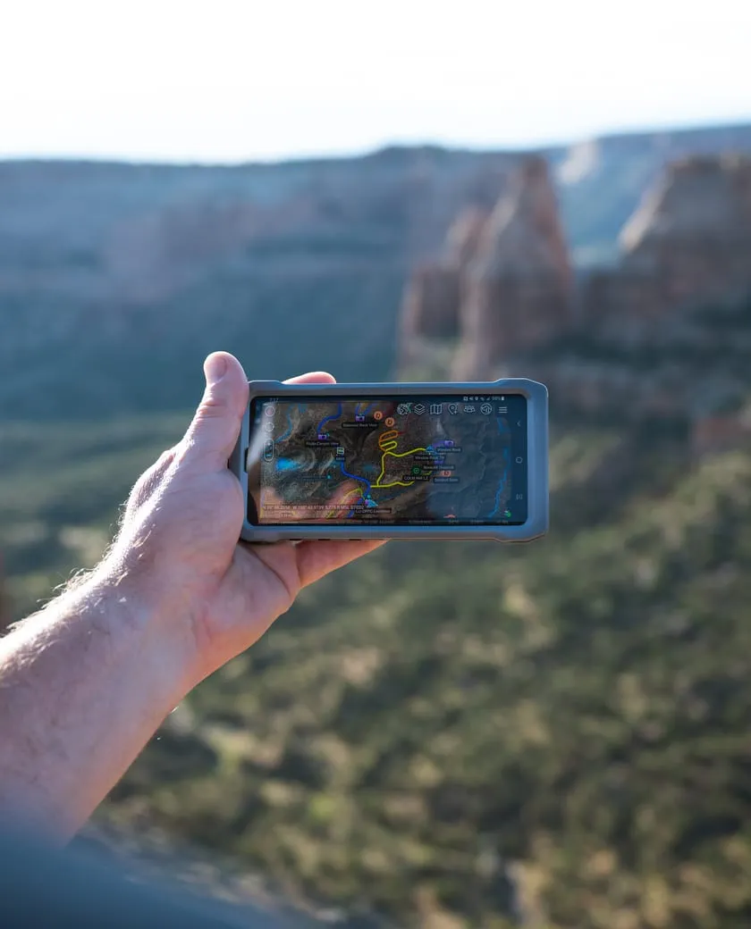 A responder holding up a phone running ATAK above the canyons of Colorado National Monument